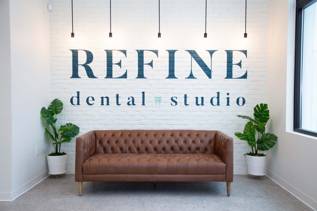 Refine Dental Studio logo painted on the wall above a coach.